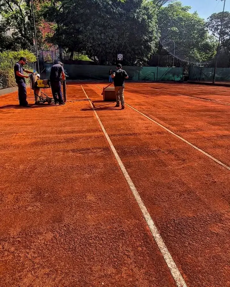 Equipe da 7 Sports na manutenção de uma quadra de saibro, com as linhas brancas novas